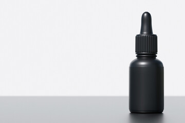 black supplement oil dropper bottle on neutral background