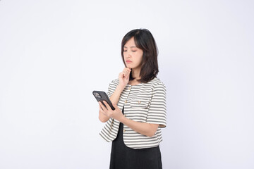 Naklejka premium Asian woman is thinking the news on her mobile phone against a white background.