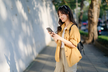 Traveler young asian woman in her 30s uses her phone to capture Bangkok's vibrant energy. Connect, explore, and discover with her journey.