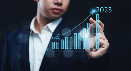 Businessman analyzing company's financial revenue and profit with value increasing charts calculation for new year, information computer system technology, using data to calculate business strategy.