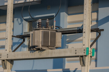 The transformer on a concrete pole. Three-phase transformers and rafts on rails for industrial plants. Transformer on concrete column beams.