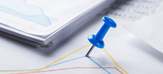 Marking financial chart by pins.Share listing and checking financial chart. Concept of banking, financial report and financial audit.