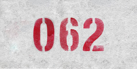 Red Number 062 on the white wall. Spray paint.