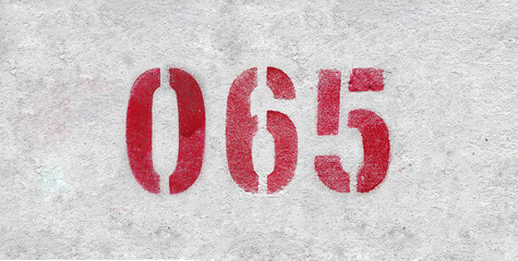 Red Number 065 on the white wall. Spray paint.