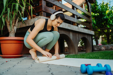One young caucasian woman is carrying and placing yoga mat preparing for training	
