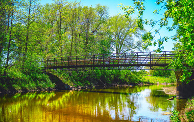 Footbridge over the Big Sioux River in Sioux Falls, South Dakota: The tranquil vibrant nature conservation area at the Spencer Park