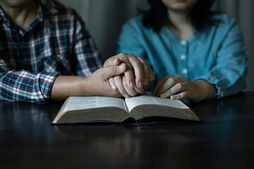Hands clasped in prayer, Christians express their faith in God and worship Jesus Christ in the...