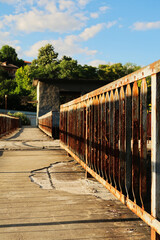 Rusted, rusty railing, handrail, rail on old concrete with potholes at an abandoned dam on the...