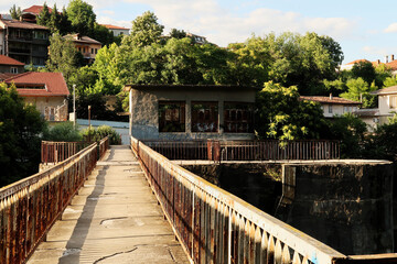 An abandoned dam on the Yantra River, rusted, rusty railings, handrails, rails on both sides of the concrete bridge, Veliko Tarnovo, Bulgaria