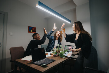 A diverse group of colleagues enthusiastically high-fiving in an office, celebrating successful...