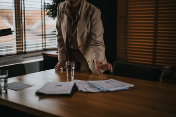 Photo of a creative professional standing at a meeting table, gesturing during a discussion with...