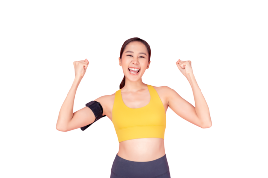 A cheerful young woman in a yellow sports bra and black workout pants celebrating her fitness achievement. She has a smartphone armband and is smiling brightly, exuding energy and motivation against a - Powered by Adobe