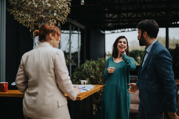 Two business partners sharing a laugh during a casual meeting with coffee on a terrace.