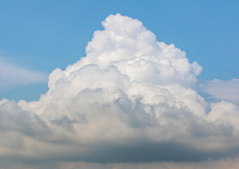 Thunderstorm clouds rising against blue sky
