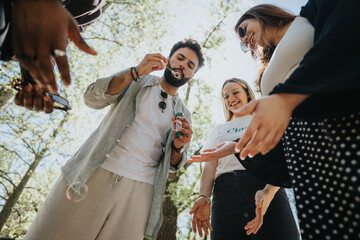 A group of friends in casual clothing enjoys a carefree weekend in the park, playing with bubble wands on a sunny day, embodying joy and freedom.