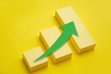 Yellow growing graph with green arrow up; Business success concept