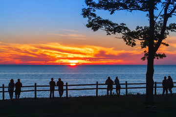 People watching sunset over water
