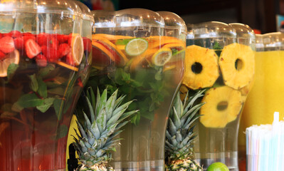 Drinks on tap. Drink bar. Assortment of lemonades at the fair in summer. Food court. Street food. Refreshing drinks. Lemonades with strawberries, mint and pineapple