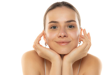 Young smiling teenage girl without makeup posing on a white studio background