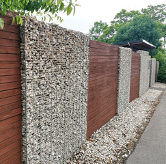 A fence made using gabion technology, a fence made of wood, metal mesh and stones