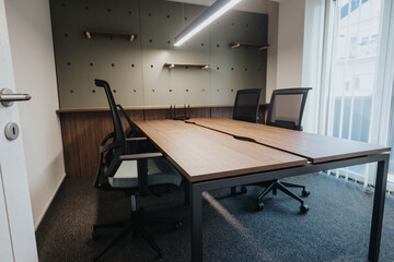 A well-lit modern office meeting room featuring a large wooden table, ergonomic chairs, and stylish wall shelves.