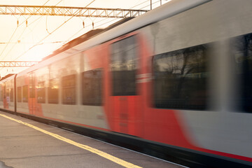 blurry photo of a moving passenger train. Train moving fast. Railroad. Public transportation.