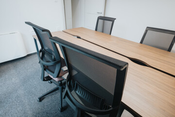 Contemporary boardroom featuring sleek chairs and a spacious wooden table, ideal for corporate...