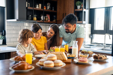 Children having breakfast with parents in home atmosphere.