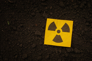 A radiation warning sign on a background of soil. Close up.
