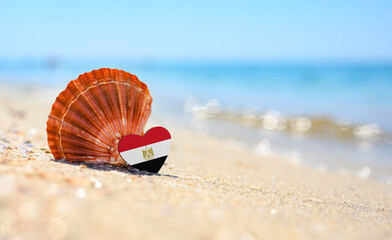 Sandy beach in Egypt. Egypt flag in the shape of a heart and a large shell. A wonderful seaside...