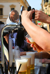 Bartender pouring a glass of ice-cold lager during an outdoor party