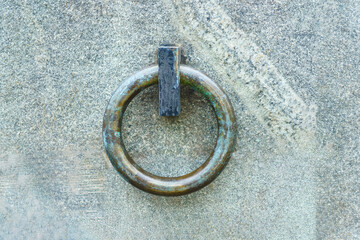 A large bronze ring embedded in a solid granite wall