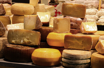 Cheese counter with aged cheeses for sale in wheels or pieces