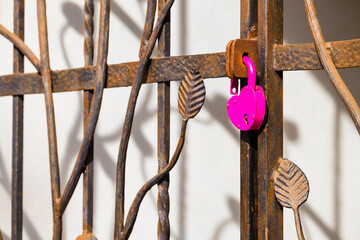 a heart-shaped padlock hanging on a metal gate