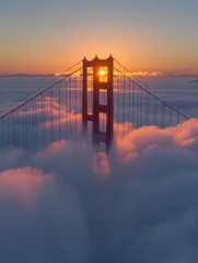 Obraz premium Golden Gate Bridge tower, red against foggy dawn, looms above soft blue sky