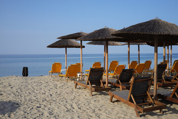 Sandy beach with sunbeds and straw umbrellas on the Olympic Riviera, Nei Pori, Pieria - Greece