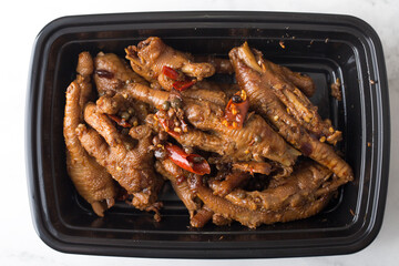 Chinese take out food spicy duck feet in a container