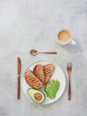 plate with avocado and toasted bread for breakfast or brunch served with a cup of coffee
