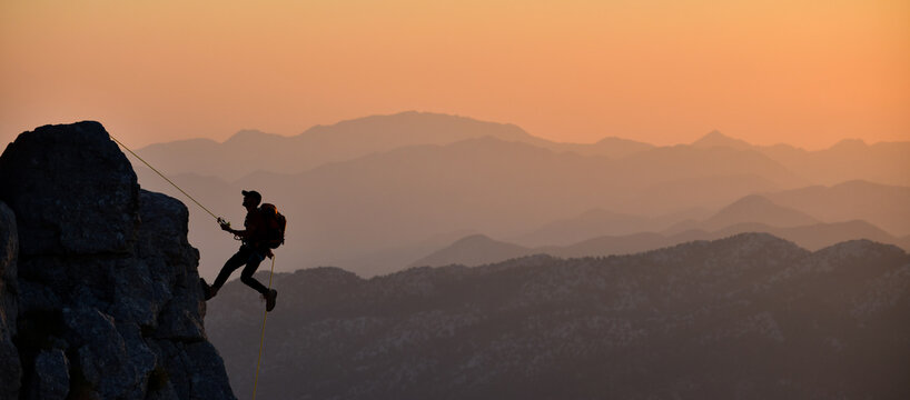 Climber On Rope Sunset Silhouette