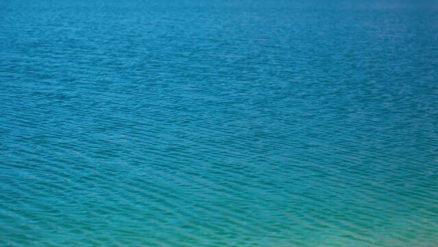 Slow motion shot of water ripples on the Chandra Taal Lake near Kunzum Pass in Spiti Valley, Himachal Pradesh, India. Water ripples on the blue water of Chandra Tal lake due to the strong winds. 