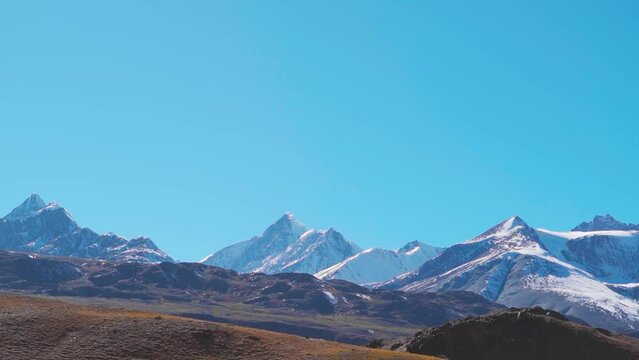 Snowy Himalayan mountain range as seen from Chandra Taal Lake in Spiti Valley, Himachal Pradesh, India. Snow covered Himalayan mountain peaks as seen from the glacial Chandratal lake in Spiti at Noon.