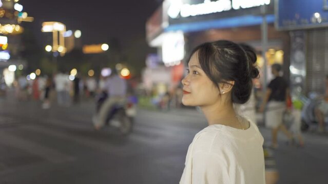Portrait of happy Asian Vietnamese woman travel at night market people walking street fair in Hanoi city, Vietnam. Retail shops
