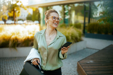 smiling modern business woman in green blouse and eyeglasses