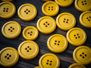 Against a grey wooden backdrop, yellow plastic buttons make a statement
