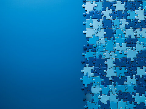 Colorful paper business puzzle pieces arranged on a blue table, offering space for text