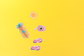 a man laying on a pool float, camera and slippers next to him on yellow summer beach background