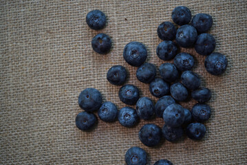 Large juicy blueberries on the background of burlap. Wild berries. Fresh blueberries.
