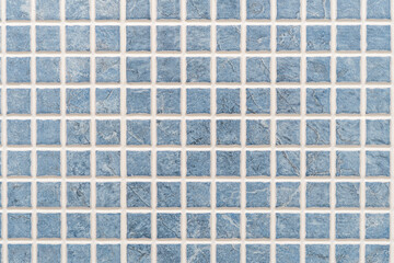 Close-up of a perfect grid of small blue ceramic tiles forming a background. High quality photo