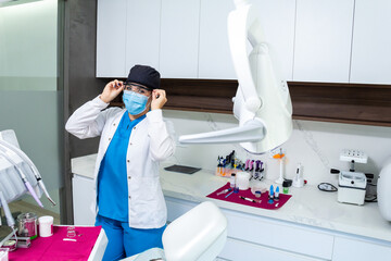 Latin hispanic dentist woman using dentistry uniform and protective safety clothing, standing next...