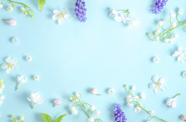 Flat lay frame from spring flowers on a light blue background. View from above, copy space. Beautiful floral frame. Springtime. aesthetics photo
